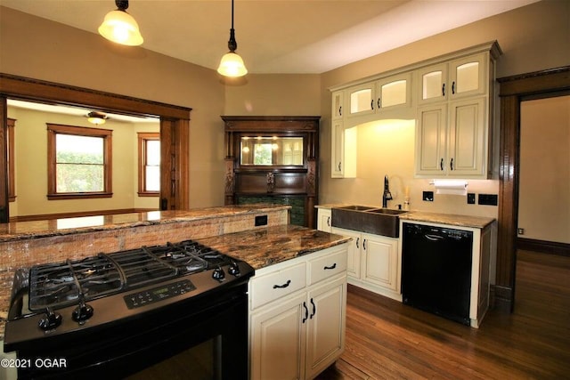 kitchen featuring dark wood-type flooring, hanging light fixtures, black appliances, white cabinetry, and sink