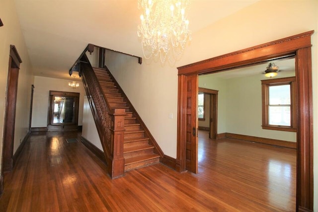 stairs featuring wood-type flooring and a notable chandelier