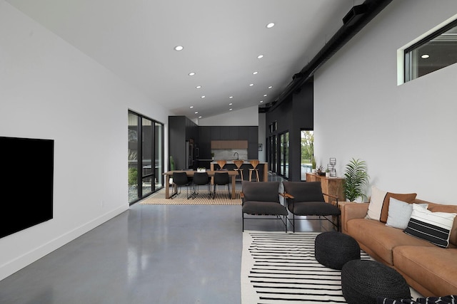 living room with high vaulted ceiling and concrete floors