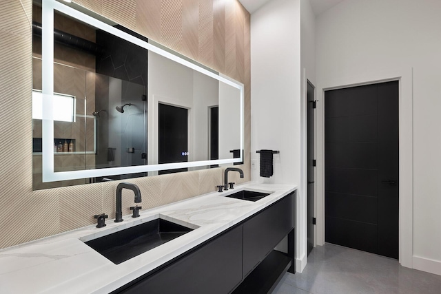 full bathroom featuring tasteful backsplash, tiled shower, a sink, and double vanity