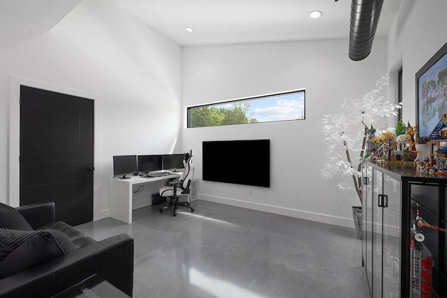 office space featuring finished concrete floors, baseboards, and recessed lighting