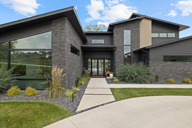 doorway to property featuring stone siding and french doors