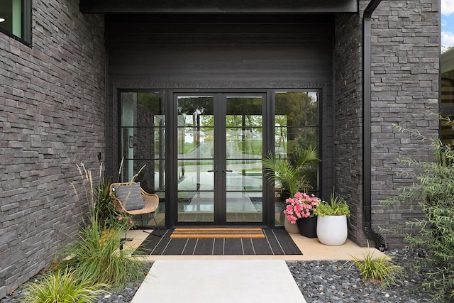 entrance to property featuring french doors and brick siding