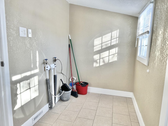 interior space featuring hookup for a washing machine and light tile patterned floors