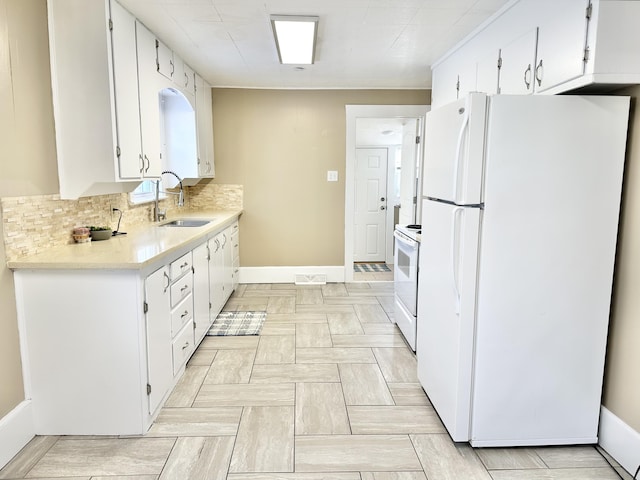 kitchen with white appliances, white cabinetry, decorative backsplash, and sink