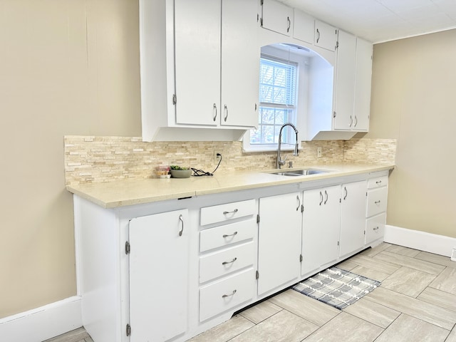 kitchen featuring sink, white cabinetry, and tasteful backsplash