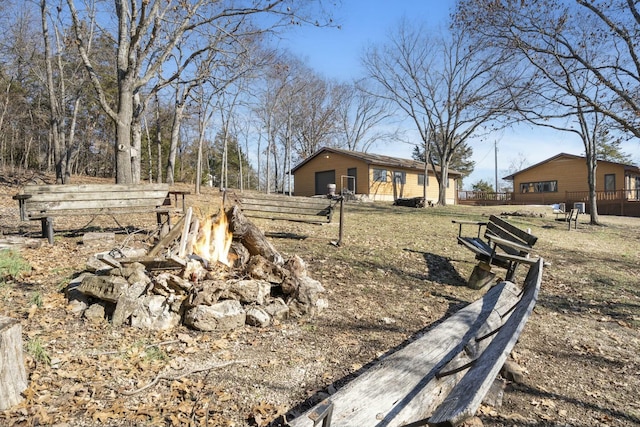 view of yard featuring an outdoor fire pit and a garage