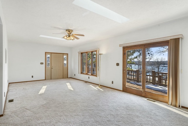 interior space featuring ceiling fan, light carpet, and a wealth of natural light