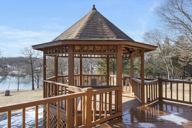 snow covered deck with a water view and a gazebo