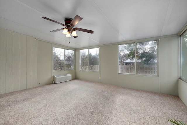 unfurnished sunroom with ceiling fan and an AC wall unit