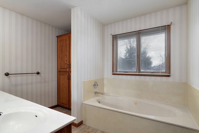 bathroom with vanity and a washtub