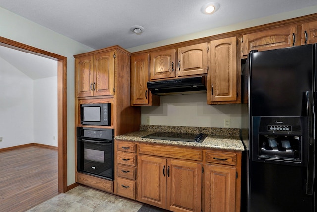 kitchen with black appliances and light stone counters