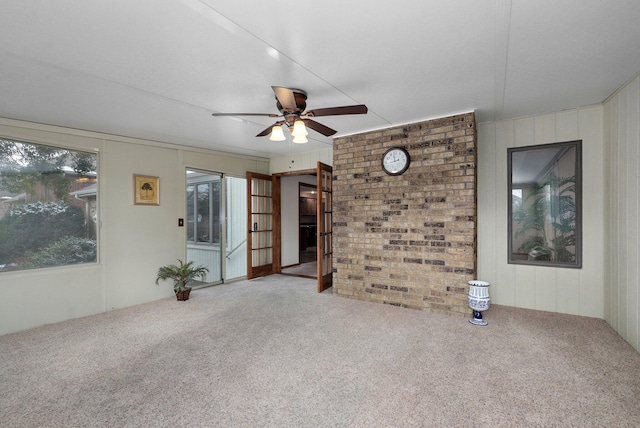 unfurnished living room featuring ceiling fan and carpet flooring