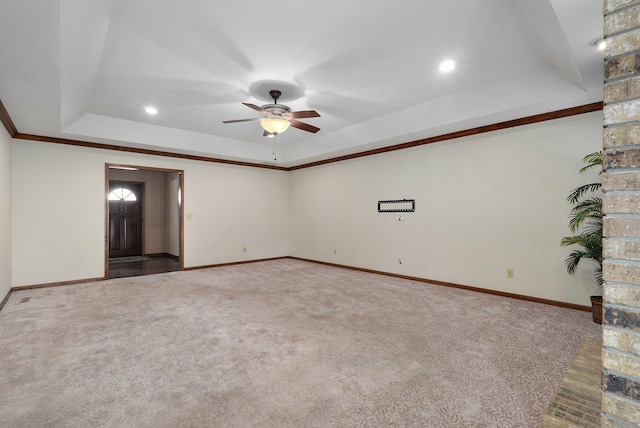 carpeted empty room featuring ceiling fan, a tray ceiling, and crown molding