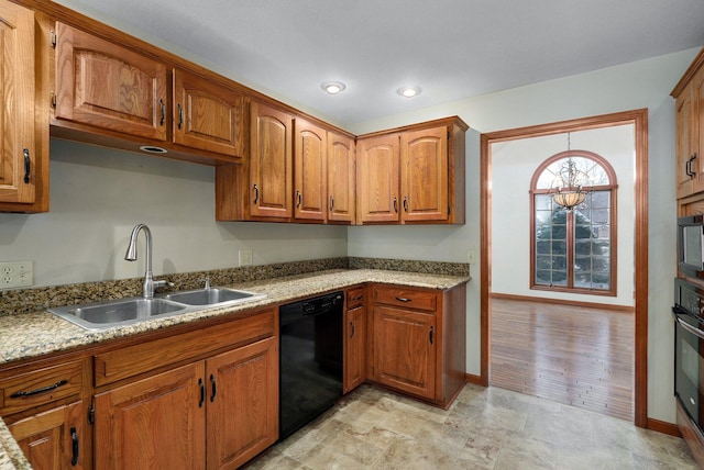 kitchen with black appliances, a notable chandelier, sink, and light stone counters