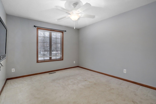 spare room featuring light carpet and ceiling fan