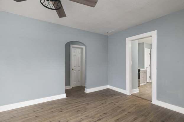 empty room featuring ceiling fan and dark wood-type flooring