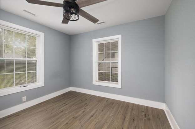 unfurnished room featuring ceiling fan and dark wood-type flooring