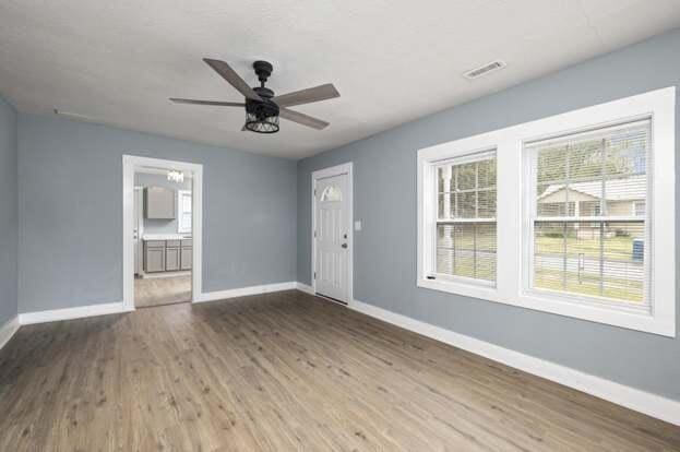 empty room with ceiling fan and hardwood / wood-style floors