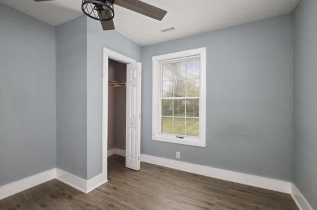 unfurnished bedroom featuring ceiling fan, a closet, and dark hardwood / wood-style floors