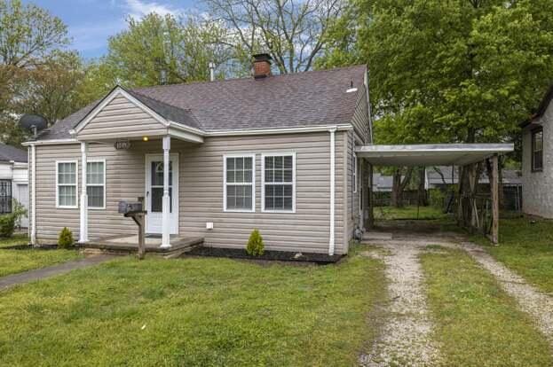 bungalow-style house with a carport and a front lawn