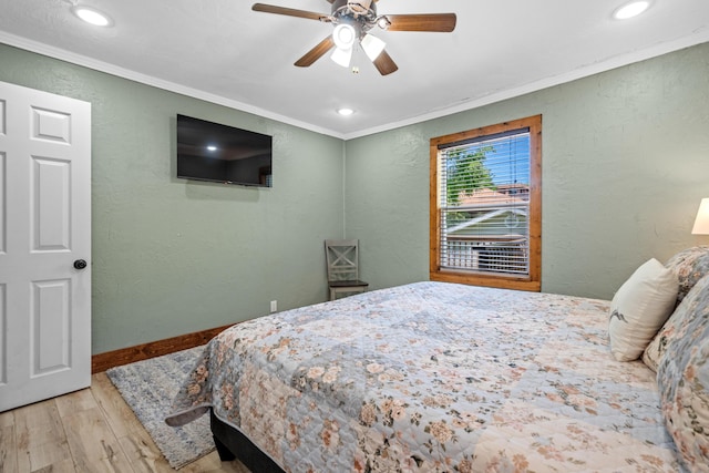 bedroom with ceiling fan, ornamental molding, and light wood-type flooring