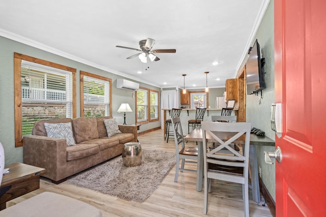 living room with ceiling fan, an AC wall unit, ornamental molding, and light hardwood / wood-style floors