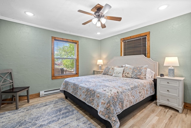 bedroom with light wood-type flooring, ceiling fan, crown molding, and baseboard heating