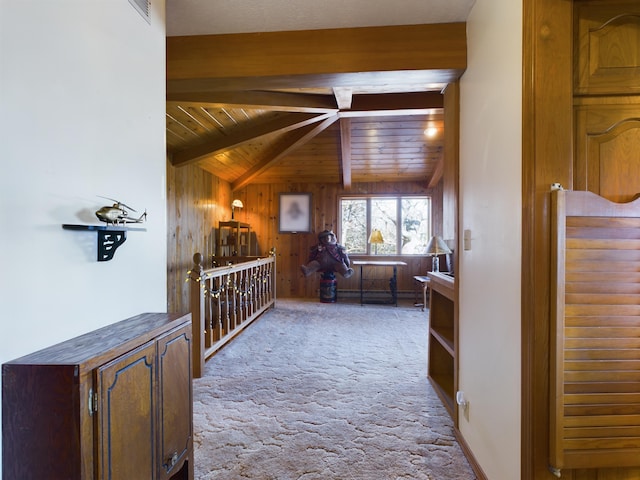 corridor featuring wooden ceiling, wood walls, light carpet, and beam ceiling