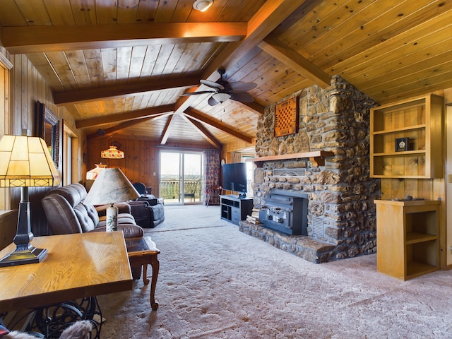 living room featuring carpet flooring, a wood stove, ceiling fan, wood walls, and lofted ceiling with beams