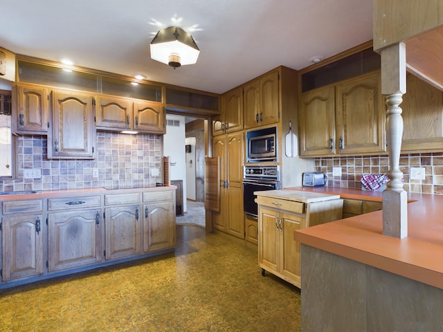 kitchen with stainless steel microwave, black oven, and decorative backsplash