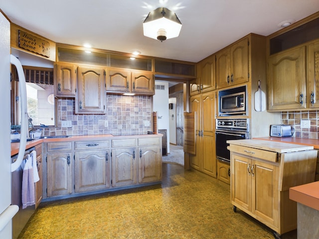 kitchen featuring stainless steel appliances, sink, and backsplash