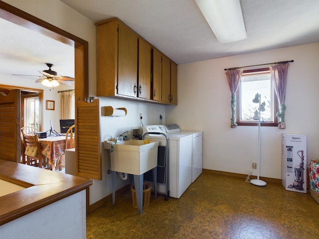 washroom featuring washing machine and dryer, cabinets, and ceiling fan