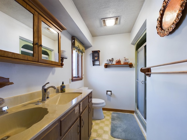 bathroom featuring toilet, an enclosed shower, a textured ceiling, and vanity