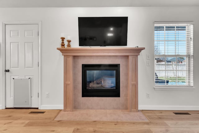 room details with a tiled fireplace and wood-type flooring