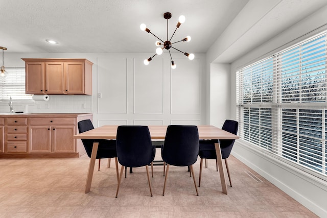 dining room with sink and an inviting chandelier