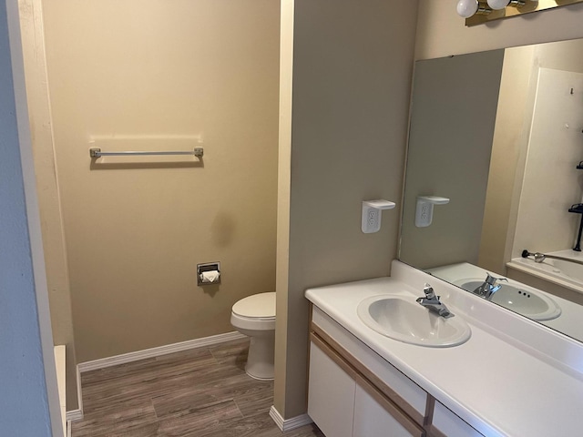 bathroom featuring toilet, wood-type flooring, and vanity