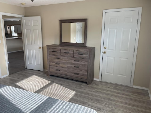 unfurnished bedroom with a textured ceiling and wood-type flooring