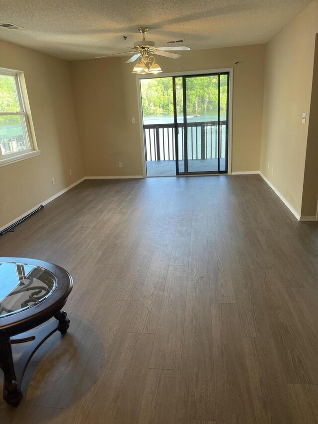 2529 State Highway 176 Unit 5, Rockaway Beach, MO 65740 - unfurnished living room with dark wood-type flooring, healthy amount of natural light, ceiling fan, and a textured ceiling