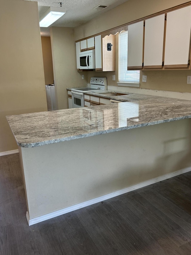 2529 State Highway 176 Unit 5, Rockaway Beach, MO 65740 - kitchen featuring white appliances, a peninsula, light stone countertops, dark wood finished floors, and a textured ceiling