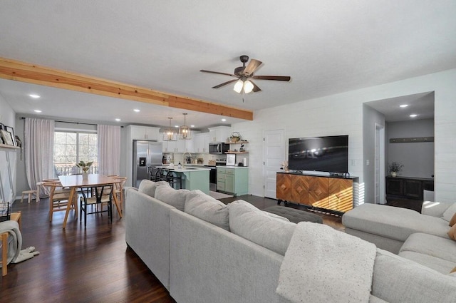 living room with sink, ceiling fan, beamed ceiling, and dark hardwood / wood-style floors