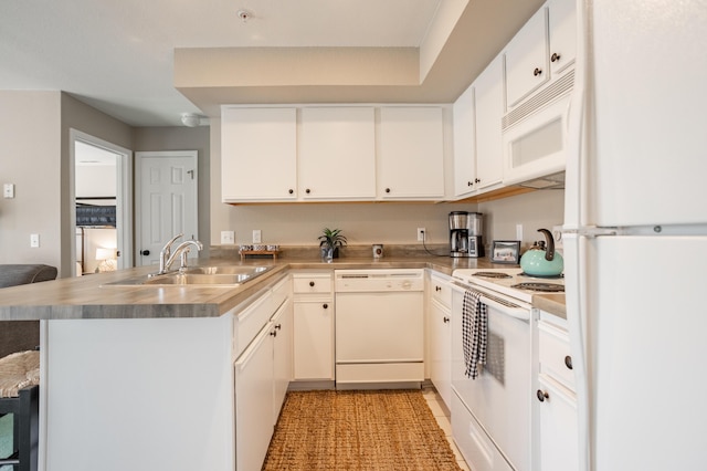 kitchen featuring sink, white cabinetry, white appliances, a kitchen breakfast bar, and kitchen peninsula