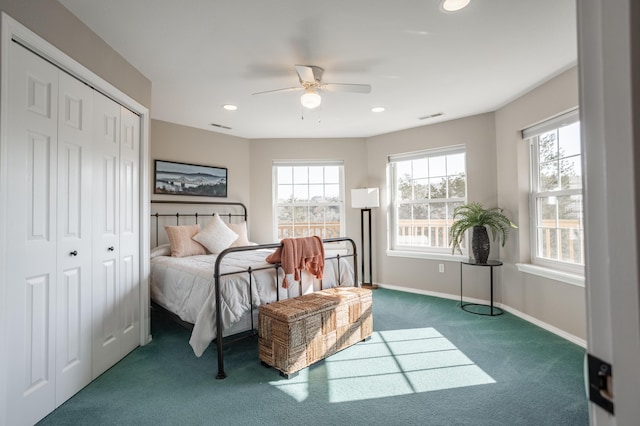 bedroom with dark colored carpet, ceiling fan, and a closet