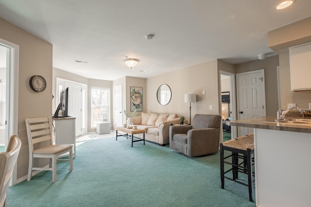 living room with sink and light colored carpet