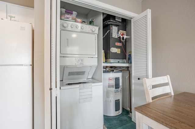 clothes washing area featuring water heater, stacked washer and clothes dryer, and heating unit