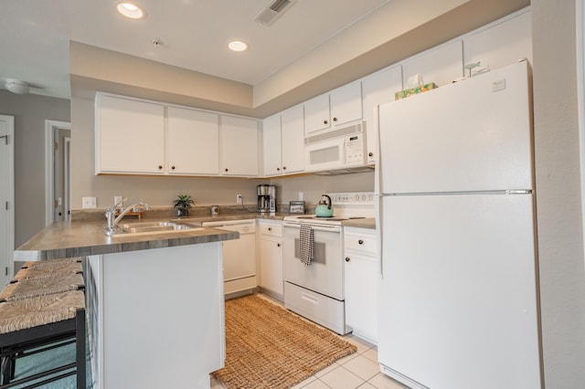 kitchen with white appliances, a kitchen breakfast bar, white cabinetry, and sink