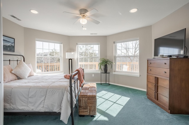 carpeted bedroom featuring ceiling fan and multiple windows