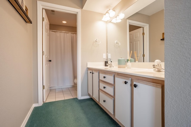 bathroom with toilet, vanity, and tile patterned flooring