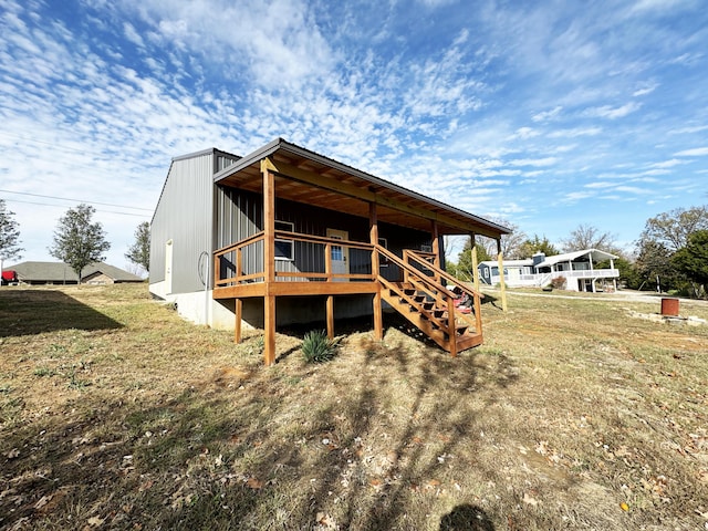 back of property with a deck and a yard