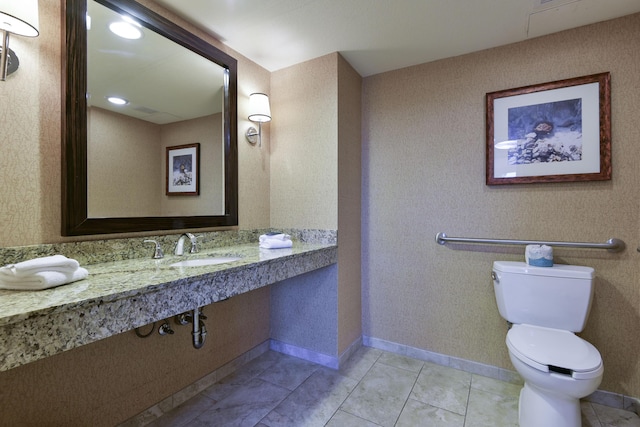 bathroom with toilet, tile patterned floors, and sink